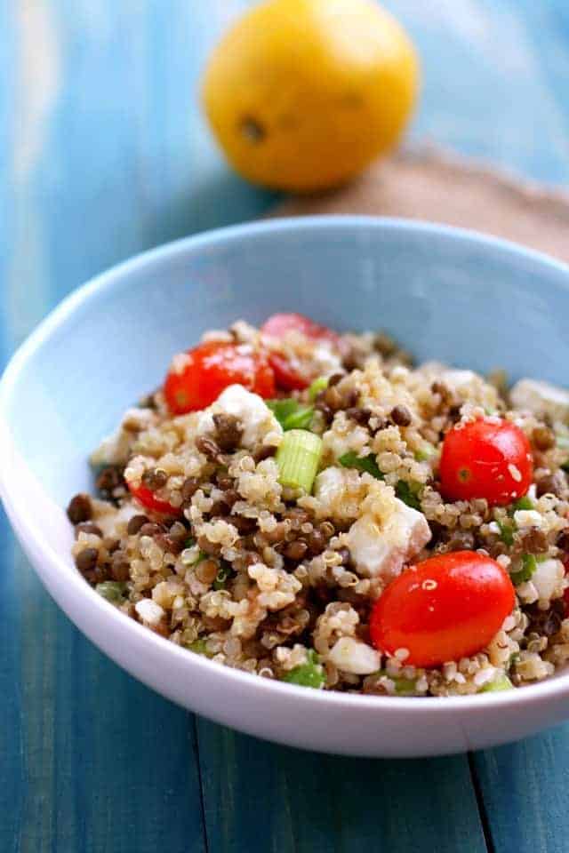 lentil quinoa salad with cherry tomatoes in a light blue bowl