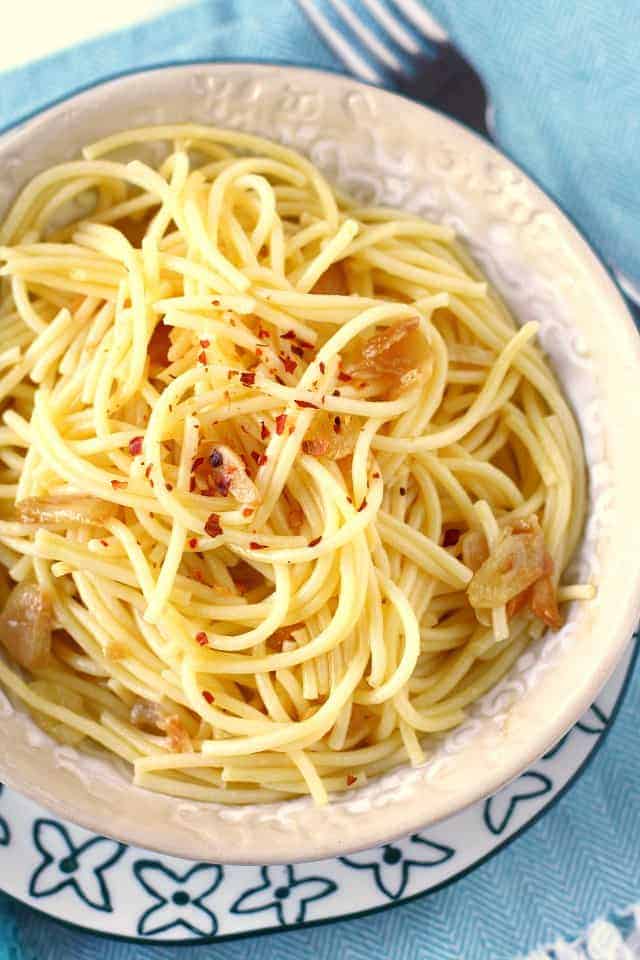 garlic spaghetti with red pepper flakes in a white bowl