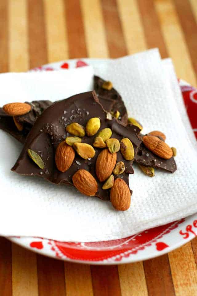 This decadent dark chocolate bark with almonds and pistachios requires just four ingredients and a minute in the microwave! An easy dessert recipe. 