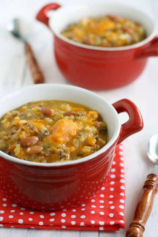Sweet potato, bean, and wild rice slow cooker soup in red crocks