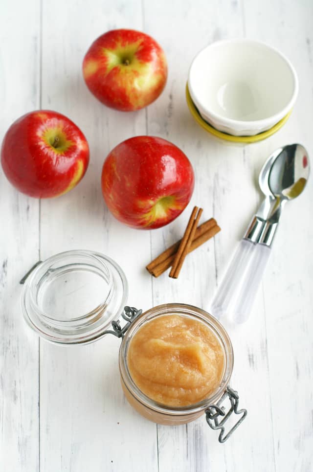 red apples and a small jar of cinnamon applesauce