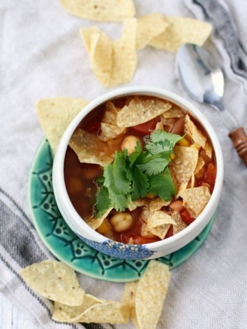 tortilla soup in a white bowl on a green plate
