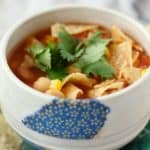 vegan tortilla soup in a white bowl with cilantro on top