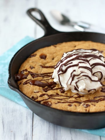 A rich and delicious chocolate chip skillet cookie that's filled with chocolate chips and topped with ice cream and chocolate sauce. Vegan and gluten free. #sponsored
