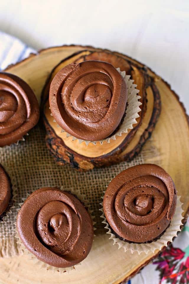 frosted gluten free chocolate cupcakes on a wooden platter