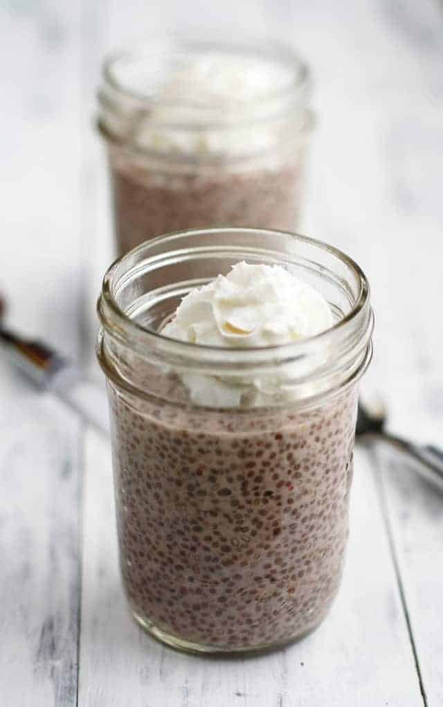 strawwberries and cream chia seed pudding in small mason jars