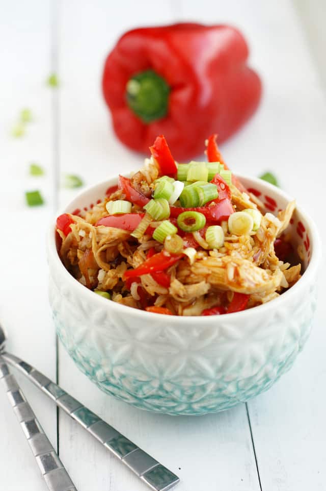 chicken teriyaki rice with red peppers and green onions in a light blue and white bowl
