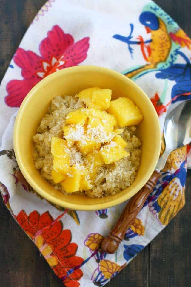 breakfast quinoa in a yellow bowl with mango