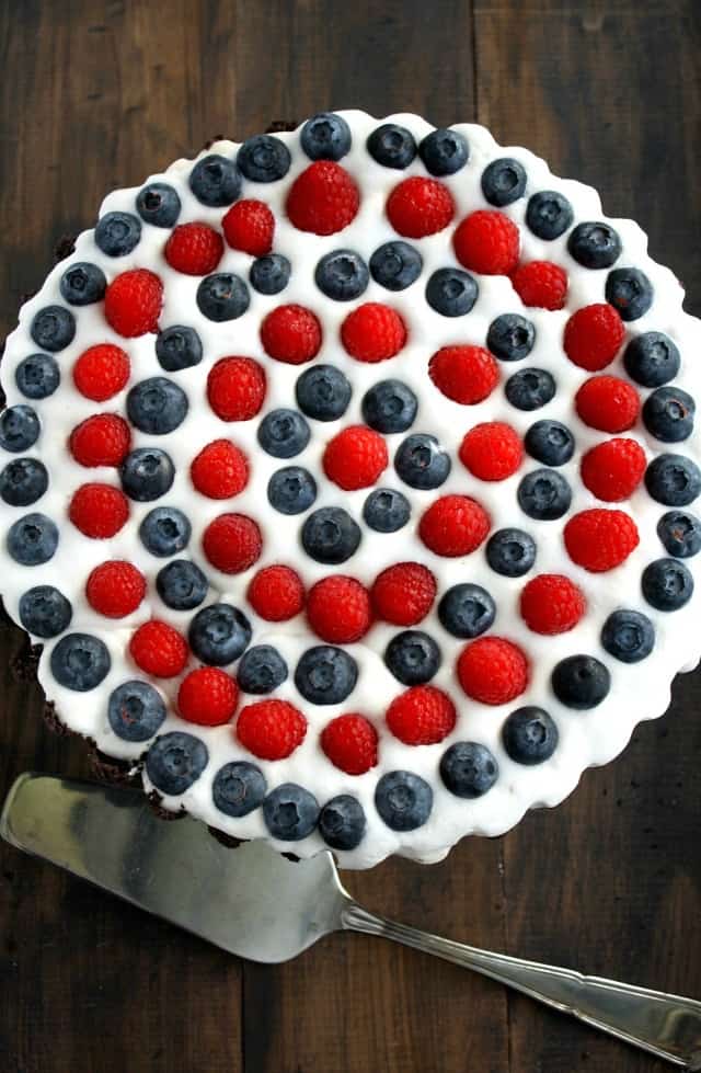 Pretty red and blue berries sit on top of a creamy filling and an Oreo cookie crust. A no-bake patriotic dessert! #july4th #patriotic #nobake