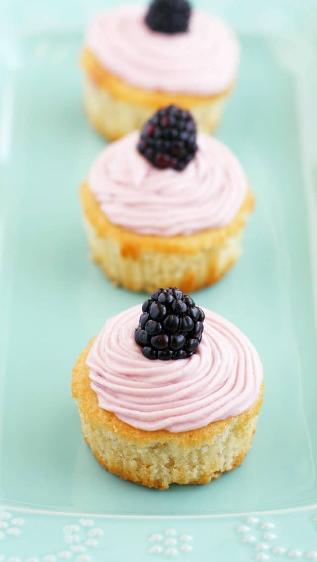 Light, fluffy, DELICIOUS lemon cupcakes topped with a sweet blackberry buttercream frosting! #cupcakes #vegan