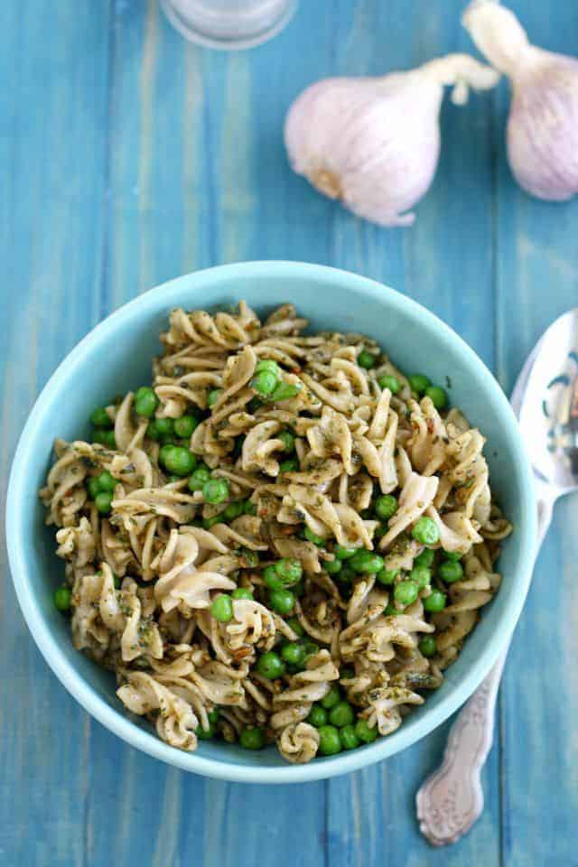 pasta salad with pesto and peas in a blue bowl
