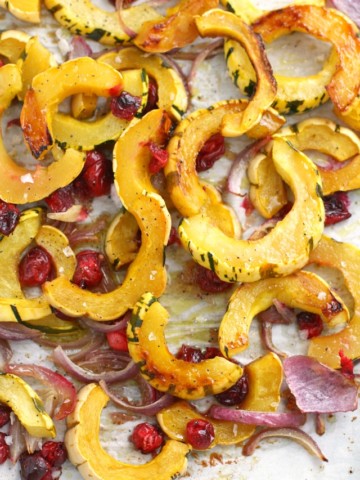 Delicata squash is so flavorful when roasted with red onions and cranberries and topped with a maple glaze. A great side for Thanksgiving!