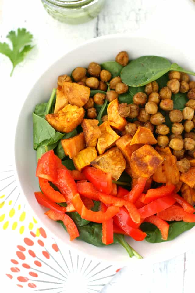 A healthy and filling salad with roasted sweet potatoes, chickpeas, red pepper, and spinach, all topped with a cilantro vinaigrette. Healthy and so tasty! Vegan and gluten free. 