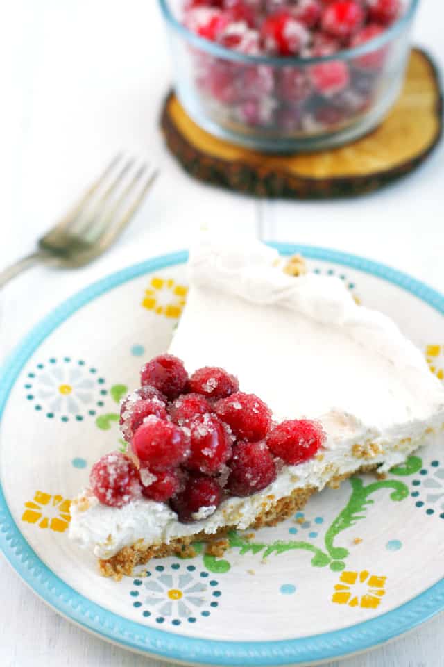slice of vegan cheesecake topped with sugared cranberries