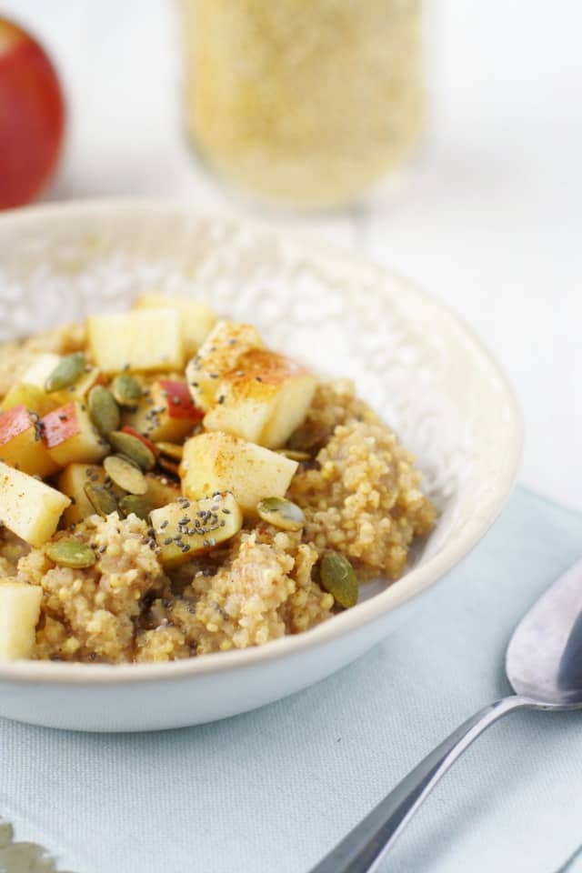 apples and millet with pumpkin seeds in a ceramic bowl
