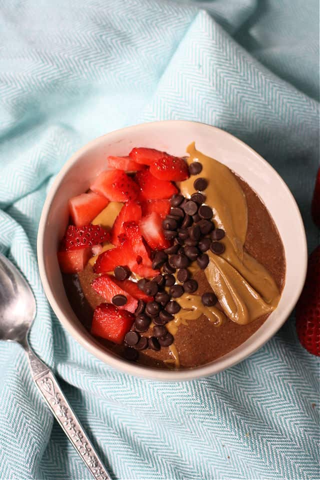 creamy chocolate chia pudding with berries and chocolate chips in a white dish