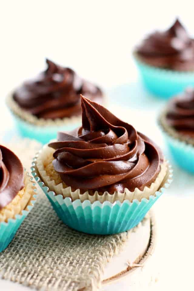 gluten free vanilla cupcakes with chocolate icing in teal cupcake wrappers