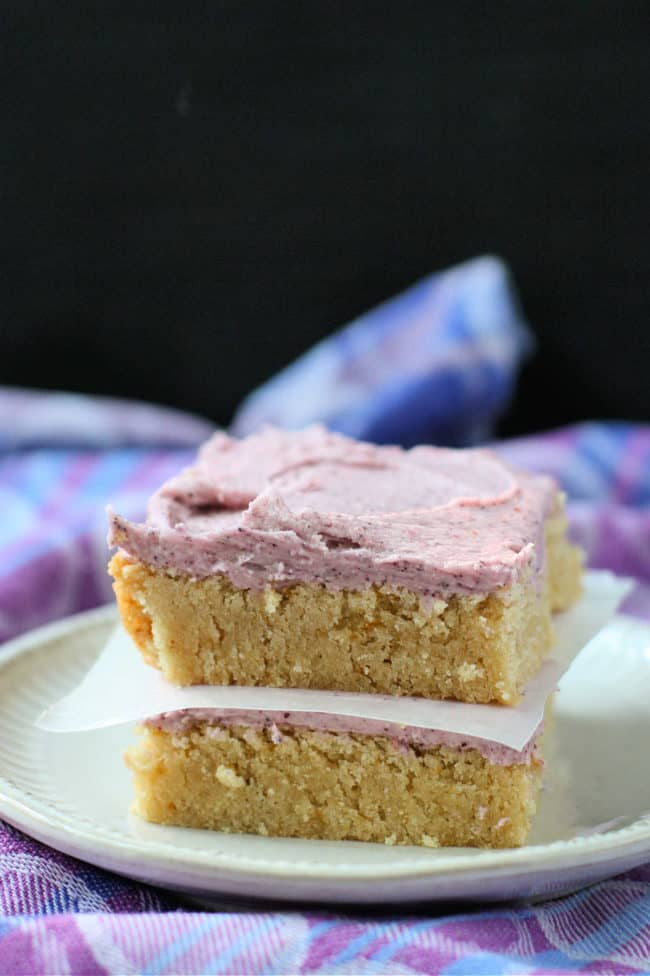 frosted sugar cookie bars stacked on a plate