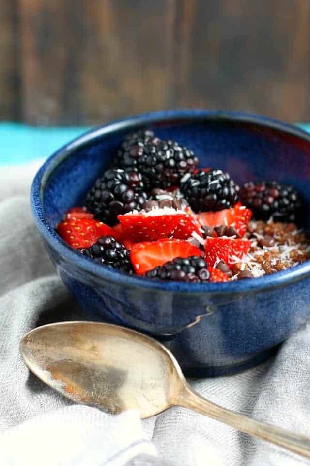 Chocolate quinoa breakfast cereal with fresh berries in a blue bowl