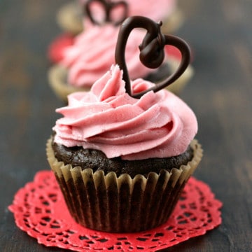 Rich chocolate cupcakes are topped with naturally dyed pink frosting and chocolate hearts. These are pretty and delicious!
