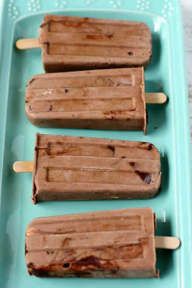 Chocolate sunbutter ice cream bars lined up on a green tray.