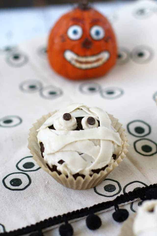 vegan mummy cupcake on a halloween tablecloth