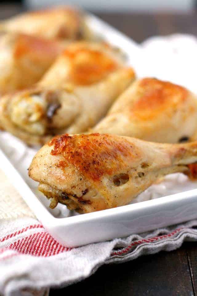 golden brown oven roasted chicken legs on a white tray