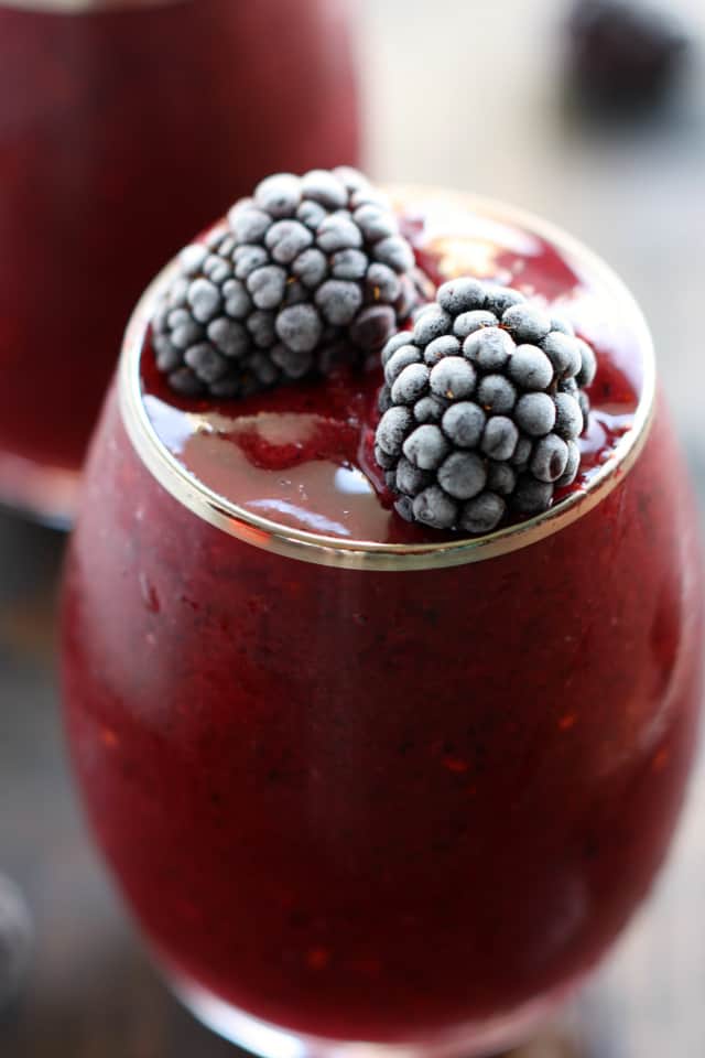 berry beet smoothie in a glass topped with blackberries