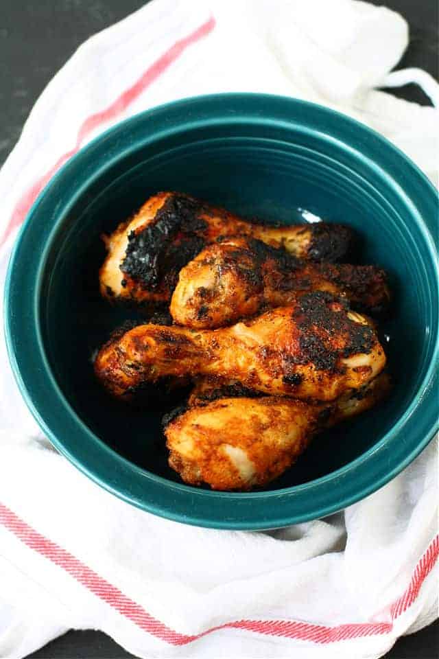 grilled chicken legs in a teal bowl