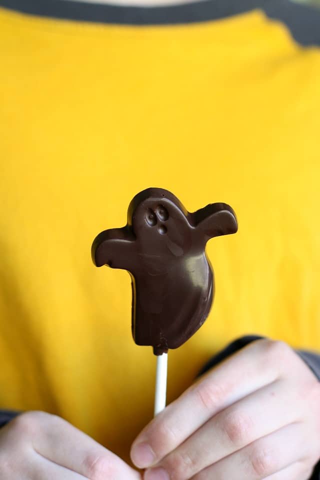 halloween chocolate lollipop being held by hands