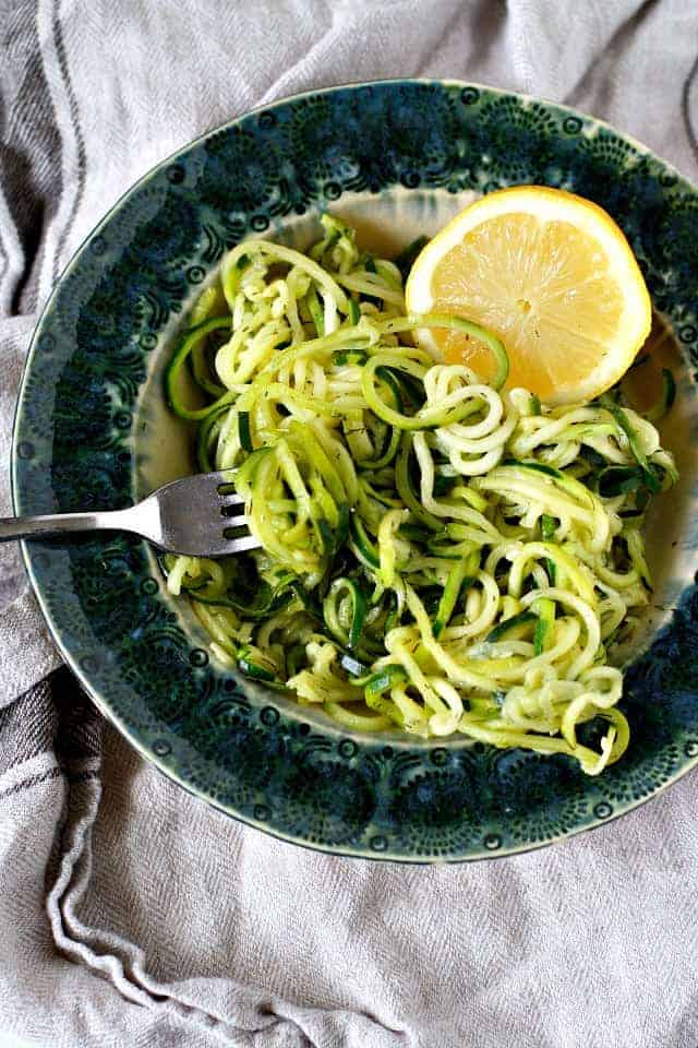 zoodles with lemon and dill in a teal dish