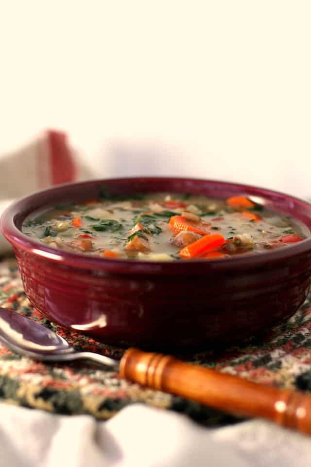 crockpot wild rice soup in a maroon bowl
