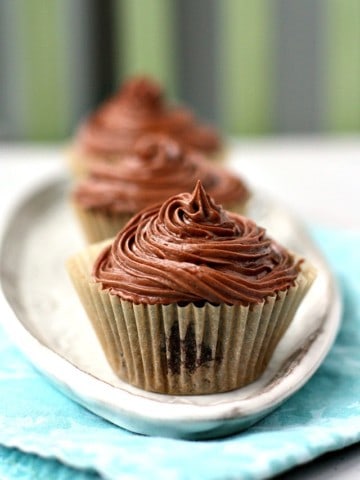 vegan chocolate frosting on a cupcake on a white tray