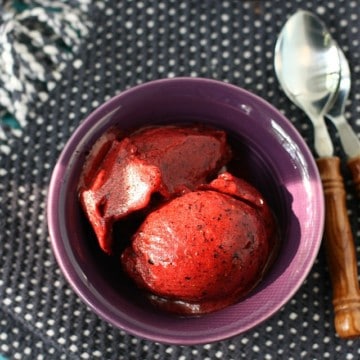 cherry berry sorbet in a violet bowl with a spoon