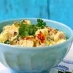 potato salad with bacon in a light blue bowl