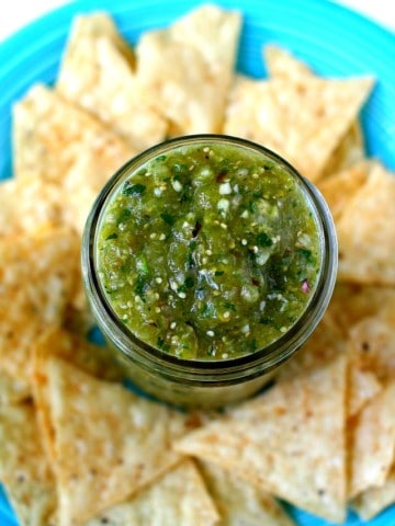 salsa verde on a blue plate with tortilla chips