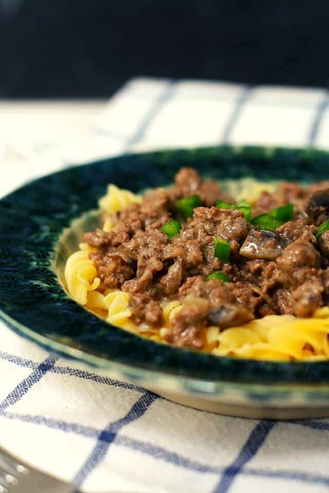 dairy free beef stroganoff in a teal bowl with noodles