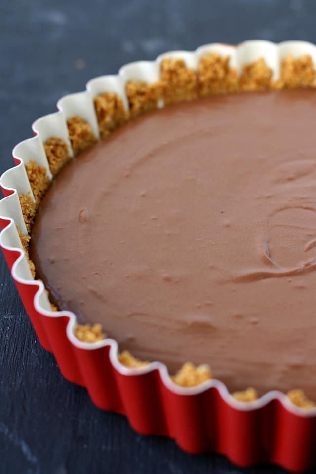 vegan chocolate silk pie in a red tart pan