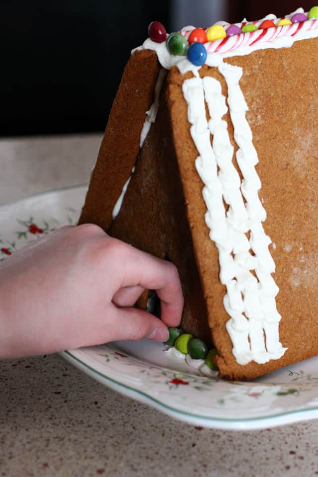 putting candy on gingerbread house