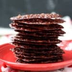 stack of chocolate lace cookies on a red plate