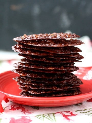 stack of chocolate lace cookies on a red plate