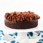 small chocolate cake on a white cake stand