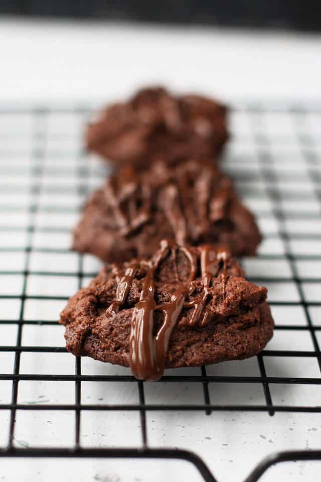 double chocolate cookies with melted chocolate on a cooling rack