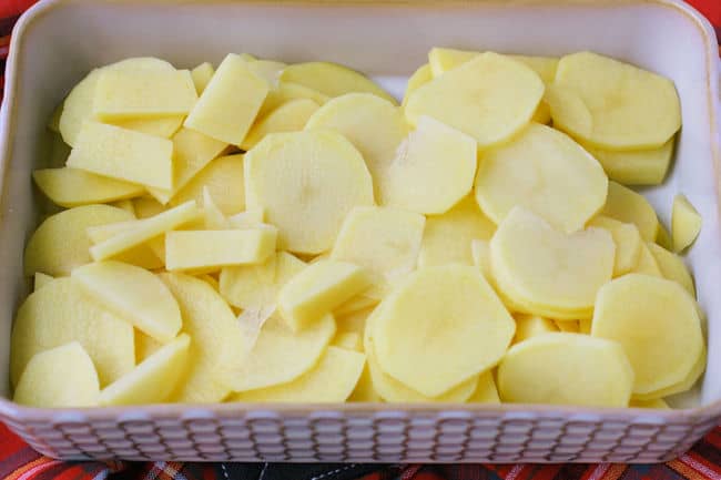 thinly sliced potatoes in a casserole dish