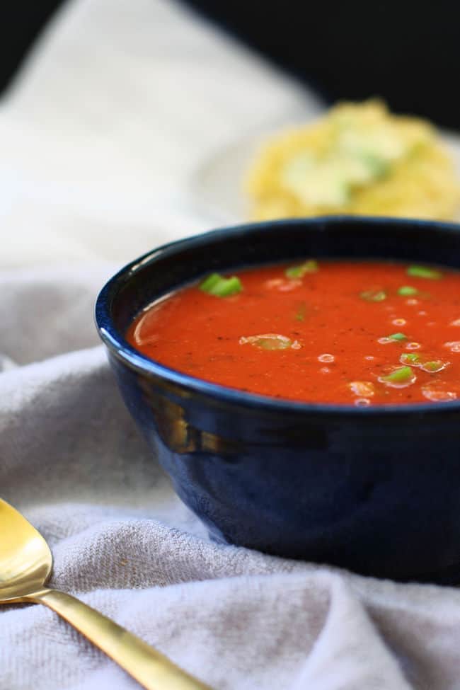 vegan tomato soup in a bowl with green onions