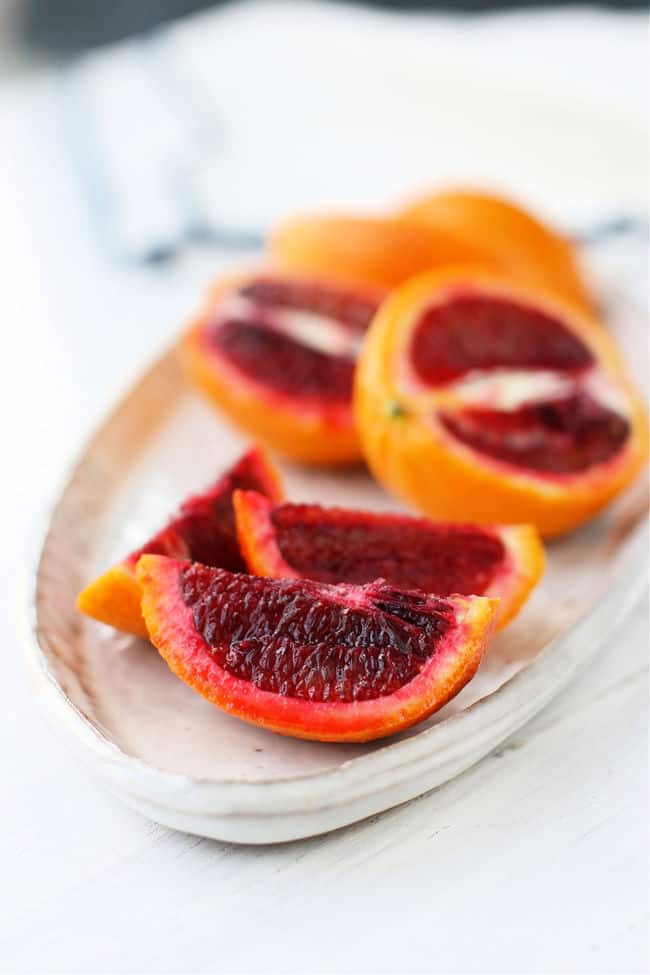 sliced blood oranges on a white tray