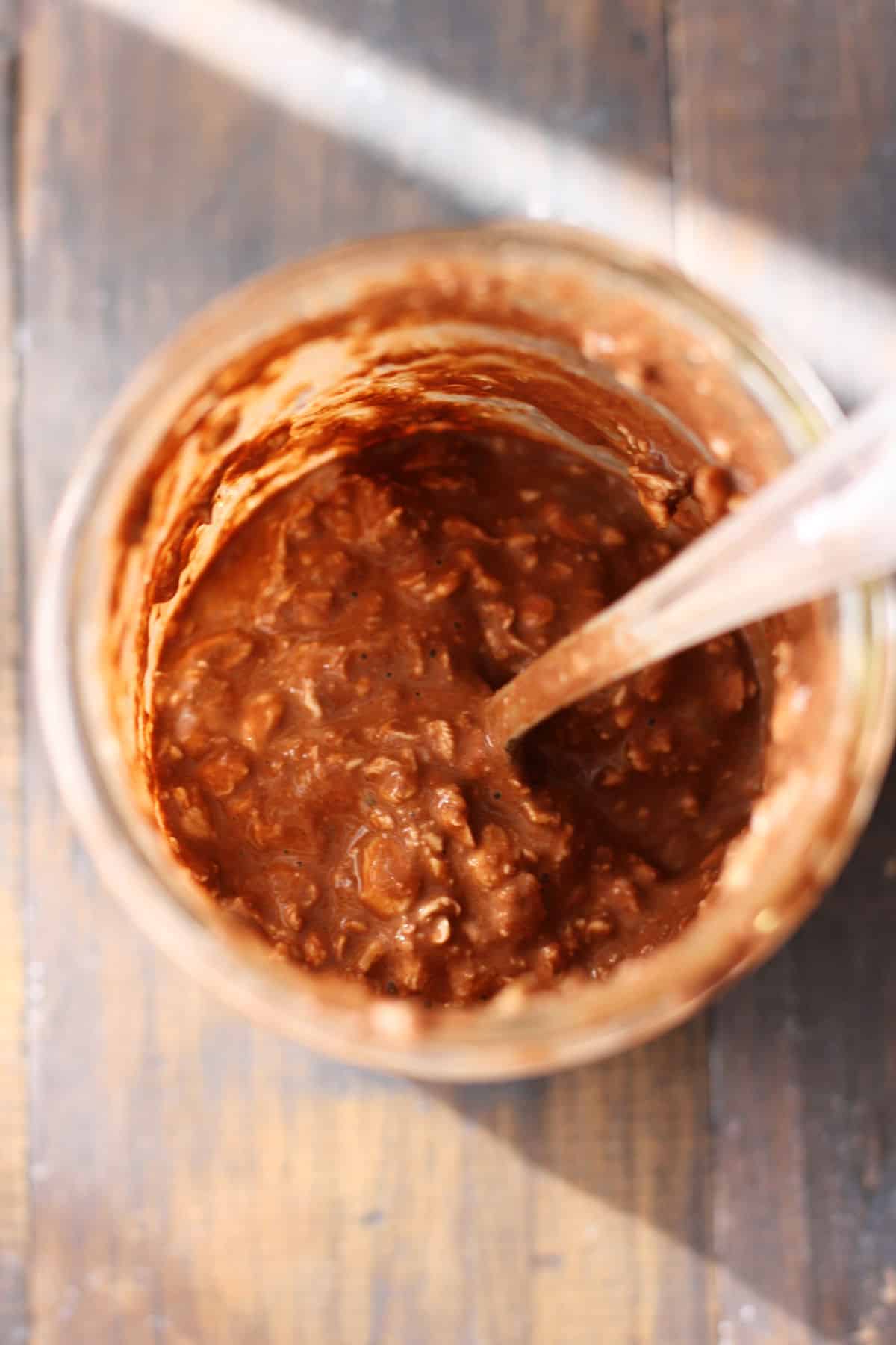 chocolate oatmeal in a jar with a spoon