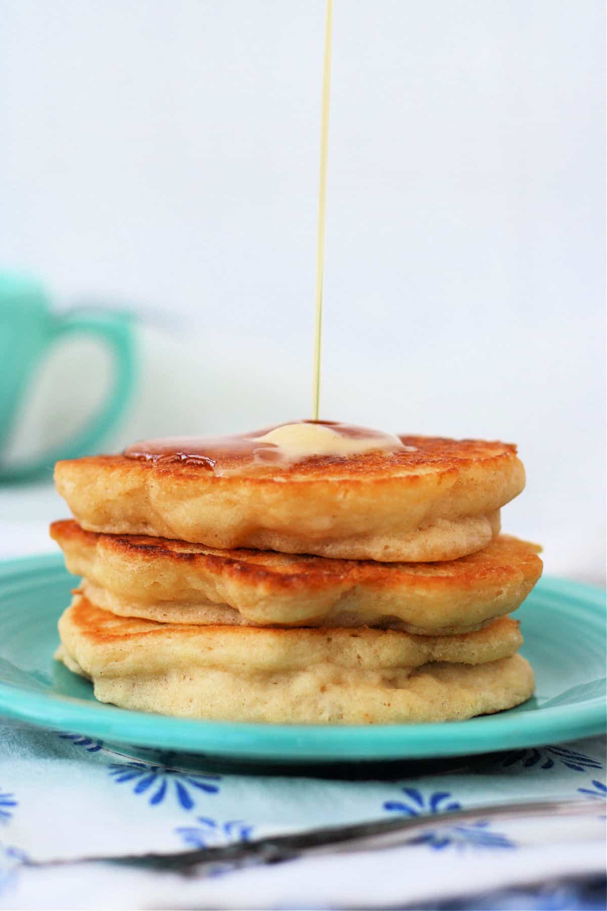 stack of three vegan pancakes with buttery spread