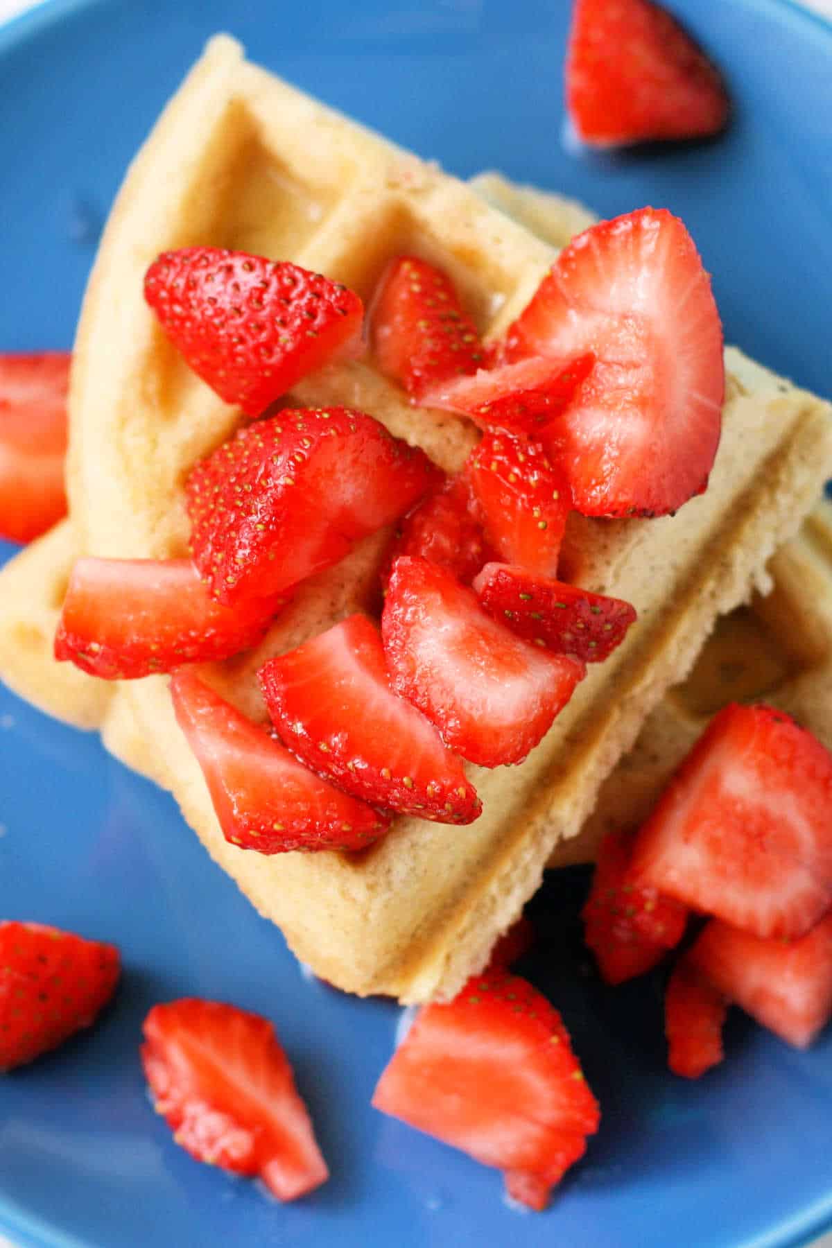 easy vegan waffles with strawberries on a blue plate