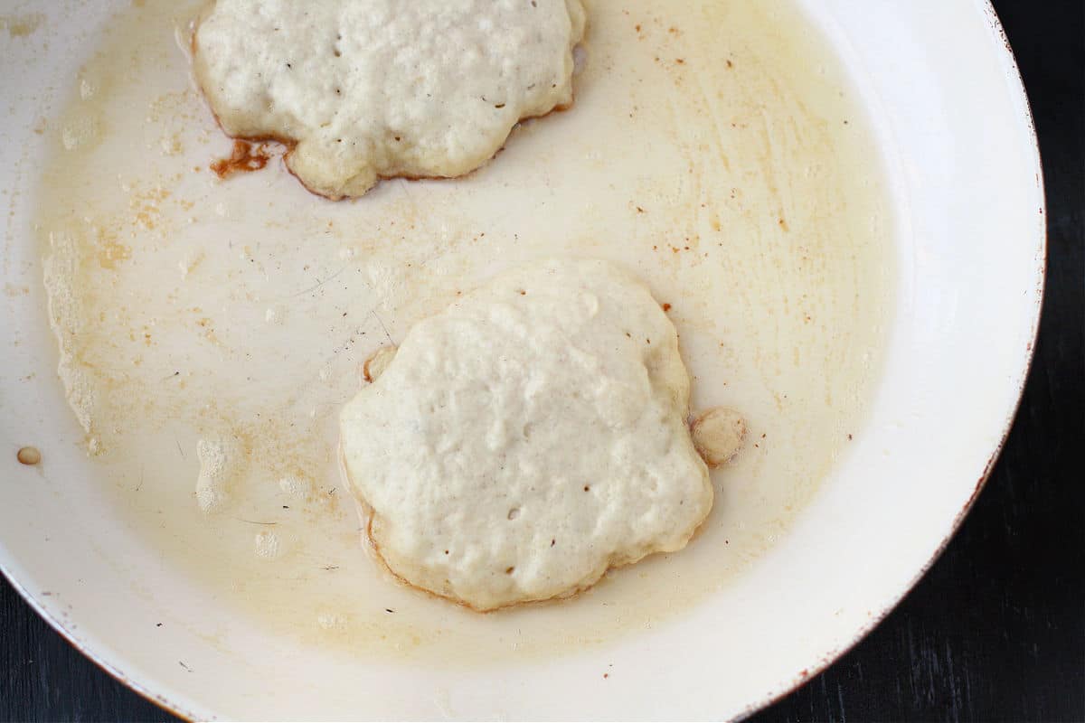vegan pancakes in pan before flipping